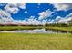 Scenic view of a serene pond, surrounded by lush green lawns and beautiful homes at 10410 Inglenook Ter, Palmetto, FL 34221