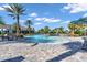 Large community pool with lounge chairs, tables with umbrellas, and lush landscaping at 10410 Inglenook Ter, Palmetto, FL 34221