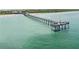 Aerial view featuring a long pier extending into the ocean, with beaches and clear, green water at 10930 Lerwick Cir, Englewood, FL 34223
