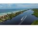 Gorgeous aerial view of waterfront property with beautiful homes, a sandy beach, and boats cruising at 10930 Lerwick Cir, Englewood, FL 34223