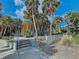 Unique building surrounded by mature palm trees with a concrete walkway and 'MANASOTA' sign at 10930 Lerwick Cir, Englewood, FL 34223