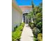 Inviting walkway to the front door, surrounded by lush landscaping and tropical plants at 10930 Lerwick Cir, Englewood, FL 34223