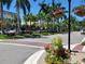 Charming street view with palm trees, colorful flowers, and well-manicured landscaping at 10930 Lerwick Cir, Englewood, FL 34223