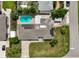 Aerial view showcasing the home's pool, solar panels, and landscaped yard in a residential neighborhood at 1099 Nokomis S Ave, Venice, FL 34285