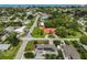 An aerial view showcases a neighborhood with lush landscaping and a glimpse of the nearby ocean at 1099 Nokomis S Ave, Venice, FL 34285