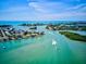 Aerial view of waterfront homes, boats, and waterways under a clear blue sky at 1099 Nokomis S Ave, Venice, FL 34285
