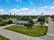 Aerial view of a charming home with a manicured lawn in a serene neighborhood setting at 1099 Nokomis S Ave, Venice, FL 34285