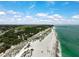 Scenic aerial view of the coastline with sandy beaches, clear water and the cityscape in the distance at 1099 Nokomis S Ave, Venice, FL 34285