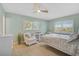 Bright bedroom with light hardwood floors, a white bed, and a comfortable sitting area at 1099 Nokomis S Ave, Venice, FL 34285
