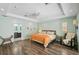 Inviting bedroom with wood floors, a seating area, and an adjoining bathroom at 1099 Nokomis S Ave, Venice, FL 34285
