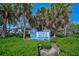 Venice Beach entrance sign surrounded by lush greenery and palm trees under a clear blue sky at 1099 Nokomis S Ave, Venice, FL 34285