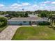 Charming light blue home features a well-manicured lawn, a brick driveway, and a cozy pergola-covered seating area at 1099 Nokomis S Ave, Venice, FL 34285