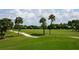 Scenic golf course with lush green fairways, palm trees, and a winding cart path for a relaxing game at 1099 Nokomis S Ave, Venice, FL 34285