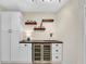Custom built-in bar featuring floating shelves and stainless steel wine cooler at 1099 Nokomis S Ave, Venice, FL 34285