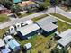 An aerial side view of a blue single-story home, garage, boats, and spacious yard at 1103 Lucille Ave, Nokomis, FL 34275