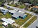 An aerial top view shows the blue single-story home in the neighborhood with boats and a garage at 1103 Lucille Ave, Nokomis, FL 34275