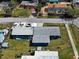 An aerial back view of a blue single-story home with a garage, boats, and spacious yard at 1103 Lucille Ave, Nokomis, FL 34275