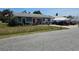 Charming home featuring blue exterior, red door, driveway, and boats parked nearby at 1103 Lucille Ave, Nokomis, FL 34275