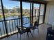 Enclosed balcony features a glass table and chairs with serene views of the community lake and fountain at 1154 Bird Bay Way # 303, Venice, FL 34285