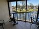 Enclosed balcony features an exercise bike with serene views of the community lake and fountain at 1154 Bird Bay Way # 303, Venice, FL 34285