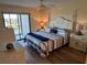 Comfortable bedroom with a king-sized bed, sliding glass doors to a balcony, and serene water views at 1154 Bird Bay Way # 303, Venice, FL 34285