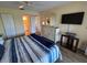 Bedroom featuring a comfortable bed, dresser, TV, and a view of the bathroom at 1154 Bird Bay Way # 303, Venice, FL 34285
