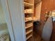 Organized closet with shelves and hanging space, featuring towels and an ironing board at 1154 Bird Bay Way # 303, Venice, FL 34285