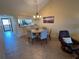 Bright dining area with round table, stylish chandelier, and access to the kitchen and living area at 1154 Bird Bay Way # 303, Venice, FL 34285