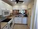 Well-lit kitchen with white cabinetry, stainless steel appliances, and a view to the living room at 1154 Bird Bay Way # 303, Venice, FL 34285