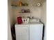 Functional laundry room with washer, dryer, and shelving for storage at 1154 Bird Bay Way # 303, Venice, FL 34285