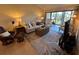 Living room featuring comfortable seating, area rug, and access to the enclosed lanai and lake views at 1154 Bird Bay Way # 303, Venice, FL 34285