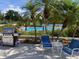 Outdoor pool area featuring a gas grill, lounge chairs, and palm trees at 1154 Bird Bay Way # 303, Venice, FL 34285