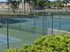 The community has tennis courts with a green fence and lush landscaping at 1154 Bird Bay Way # 303, Venice, FL 34285