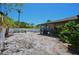 Backyard of home features a screened in porch, desert landscaping, and a white vinyl fence at 1203 Hudson Rd, Venice, FL 34293