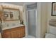 Cozy bathroom featuring a single sink vanity, mirrored cabinet, and walk-in shower at 1203 Hudson Rd, Venice, FL 34293