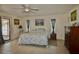 Spacious main bedroom with tiled floors, ceiling fan, ensuite bath, and access to the outdoors at 1203 Hudson Rd, Venice, FL 34293