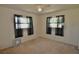 Carpeted bedroom with neutral walls, two windows, sheer curtains, and ceiling fan at 1203 Hudson Rd, Venice, FL 34293