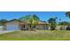 Charming single-story home with a stone facade, manicured lawn, and mature trees at 1203 Hudson Rd, Venice, FL 34293