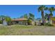 Home featuring a well manicured lawn and mature landscaping with palm trees at 1203 Hudson Rd, Venice, FL 34293