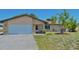 Charming single-story home with a two-car garage, beige exterior, and well-manicured lawn at 1203 Hudson Rd, Venice, FL 34293