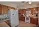 Functional kitchen features oak cabinetry, white appliances, and easy to clean tile flooring at 1203 Hudson Rd, Venice, FL 34293