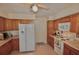 Functional kitchen featuring wood cabinets, white appliances, and tile flooring at 1203 Hudson Rd, Venice, FL 34293