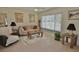 Comfortable living room featuring tile flooring, neutral decor, and natural light from the window at 1203 Hudson Rd, Venice, FL 34293