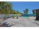 Backyard view of a rectangular pool surrounded by patio area, with a white fence and gravel in the back at 1203 Hudson Rd, Venice, FL 34293