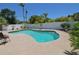 Backyard view of a uniquely shaped pool with clear water and a large surrounding patio and a white vinyl fence at 1203 Hudson Rd, Venice, FL 34293