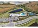 Stunning aerial view of community clubhouse, pool, tennis courts, and surrounding landscape, highlighting luxury amenities at 12538 Somatic Ct, Venice, FL 34293