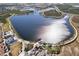 Aerial view of a large lake, walking paths, a pier, and community amenities at 12538 Somatic Ct, Venice, FL 34293