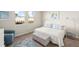 Well-lit bedroom with two windows, stylish decor, and a cozy blue armchair at 12538 Somatic Ct, Venice, FL 34293