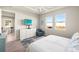 Bright bedroom featuring neutral walls, a TV, and two windows providing natural light at 12538 Somatic Ct, Venice, FL 34293