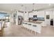 Open kitchen with white cabinets, stainless appliances, gray backsplash, and a large central island with seating at 12538 Somatic Ct, Venice, FL 34293